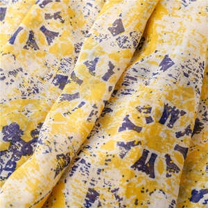 Detailed view of yellow and purple abstract print on breathable linen-textured cotton fabric