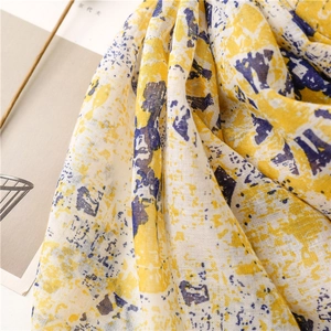 Detail shot of the abstract blue and yellow print on a lightweight linen-feel scarf