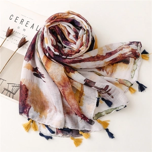 Detailed shot of watercolor print scarf with dual-tone tassels and lightweight fabric