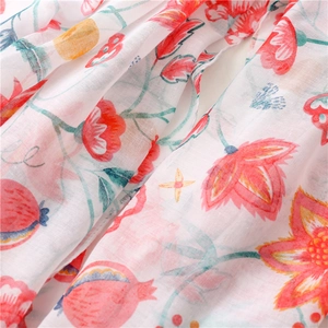 Detailed close-up of vibrant floral and pomegranate patterns on a soft cotton linen scarf