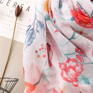Macro detail of breathable cotton-linen scarf with red floral prints and soft texture