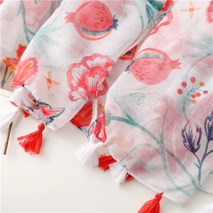 Close-up of floral pomegranate print scarf with red and white tassel fringe detail