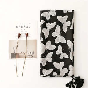 Elegant black herringbone scarf with silver butterfly print and tassels on white background