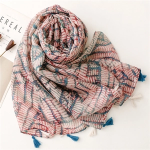 Vue détaillée d'une écharpe bohème avec motifs colorés et finitions à pompons bleus