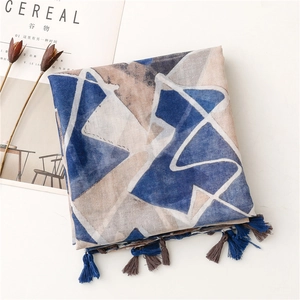 Detail of geometric printed scarf with tassel fringe and natural linen-like cotton texture