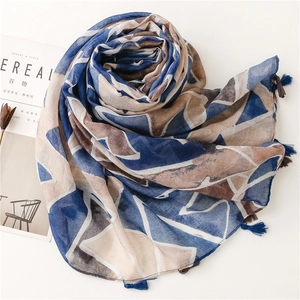 Detail of geometric printed scarf featuring blue tassels and ethnic stone patterns