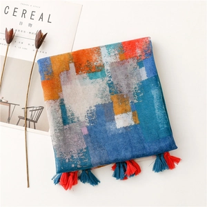 Detail view of ethnic mosaic print scarf with colorful tassels on a white background