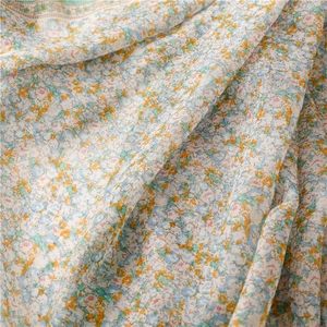 Close-up of lightweight floral fabric with delicate blue and orange prints and soft fringes
