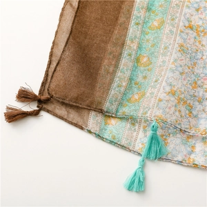 Close-up of ethnic floral cotton linen scarf featuring colorful patterns and fringe trim