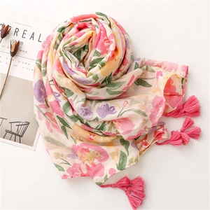 Macro shot of tropical floral scarf with pink tassels and cotton-linen herringbone texture