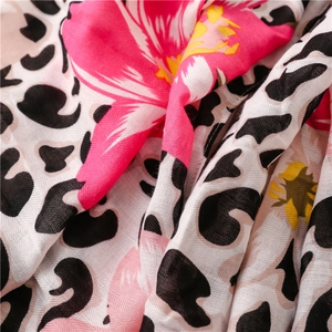 Detailed close-up showing tropical floral and leopard print patterns on cotton linen fabric