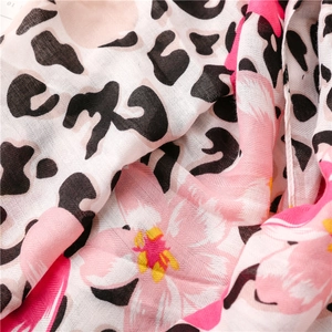 Macro shot of tropical leopard print shawl featuring pink floral patterns on linen fabric