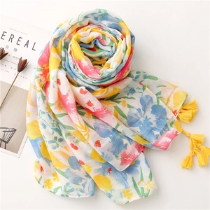 Close-up of tropical floral scarf with yellow tassels and breathable cotton-linen texture