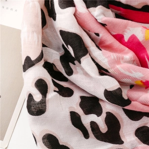 Macro shot of breathable cotton scarf featuring leopard print and colorful floral patterns