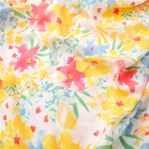 Macro detail of tropical floral print on cotton linen scarf with bright summer patterns