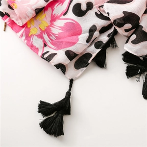 Detail of tropical floral and leopard print scarf with black tassel fringe accents