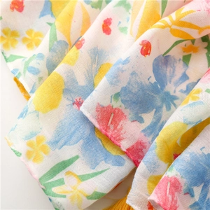 Macro view of floral printed cotton shawl with detailed texture and yellow tassels