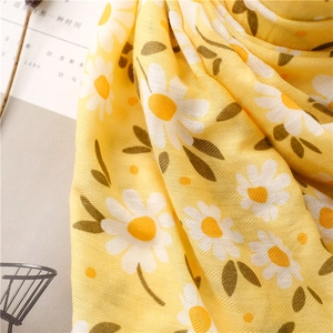 Detail of yellow daisy print scarf showing herringbone texture and soft woven cotton fabric
