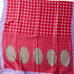 Detail eines roten Schals mit geometrischen Sternmustern und braunen Netz-Akzenten