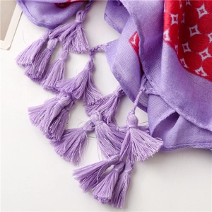 Detailaufnahme des lila Schals mit geometrischen Mustern und feinen geflochtenen Quasten