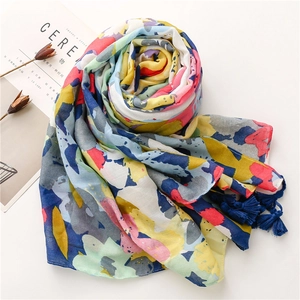 Macro detail of tropical floral pattern shawl with navy tassels and linen texture