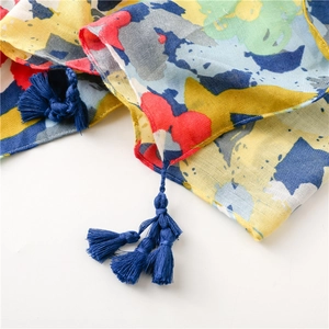 Detail of colorful tropical floral print scarf with soft texture and navy blue fringe