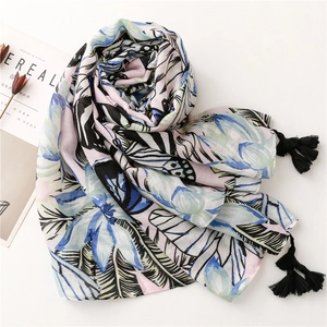 Detail of tropical floral print on a cotton-linen scarf with black fringe tassels