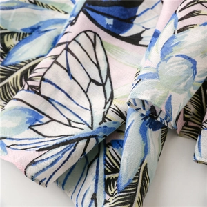 Detail of tropical floral print on lightweight linen-feel fabric with herringbone texture