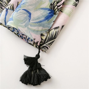 Detail of floral print shawl showing lightweight fabric texture and black tassel fringe