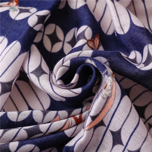 Deep blue and white geometric cotton scarf with orange floral prints and braided fringe