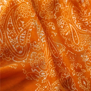 Detail of vibrant orange paisley linen-feel scarf fabric with fine texture and soft drape