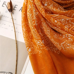 Detailed texture of orange paisley cotton linen scarf with elegant fringe detail