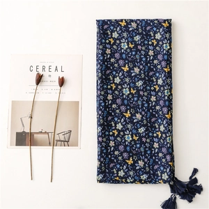 Blue cotton linen scarf with floral butterfly patterns and tassel details on white base