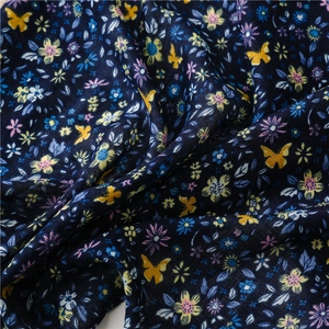 Close-up of blue cotton linen scarf with vibrant yellow butterfly and floral print