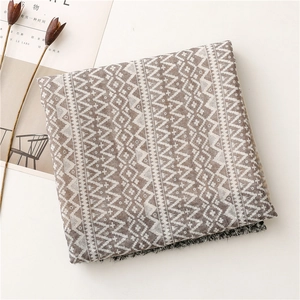 Close-up of geometric pattern scarf with earthy brown tones and fringed edge details