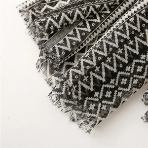 Detailed macro shot of black and white geometric ethnic patterns on a frayed edge scarf
