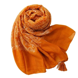Orange linen-feel scarf with white paisley prints and decorative tassels on edges