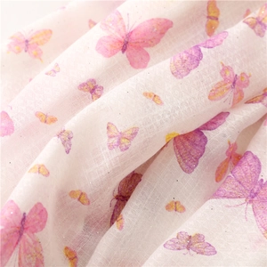 Close-up of lightweight scarf fabric with pink butterfly prints and glitter details