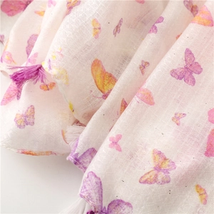 Detail of pink butterfly print on linen texture scarf with golden glitter and purple tassels