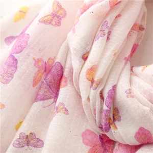 Macro shot of butterfly print on lightweight pink scarf with subtle gold glitter details