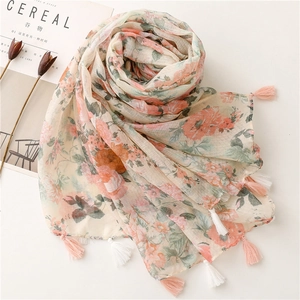 Detail of floral linen-feel scarf with pink rose patterns and handmade fringe tassels