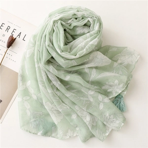 Detail of light green floral scarf with soft tassels and delicate hand-painted flower print