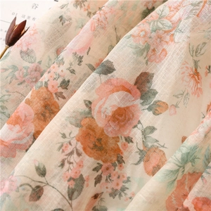 Detailed macro view of vintage rose floral pattern and light fringe on linen-feel scarf