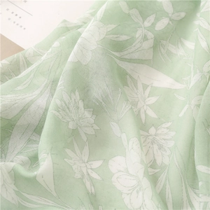 Detailed macro view of soft light green floral cotton linen scarf with elegant prints