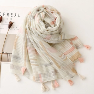 Detail of linen-feel scarf with light pink beige check pattern and handmade fringe edges