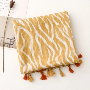 Détail d'écharpe jaune à motif zèbre avec franges colorées en tissu de fil de Bali