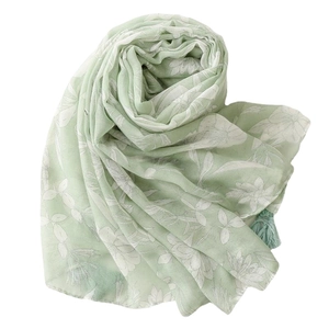 Light green linen-feel floral scarf with white flowers and tassel fringe on white background