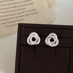 Minimalist silver braided triple hoop earrings with twisted texture on luxury jewelry box