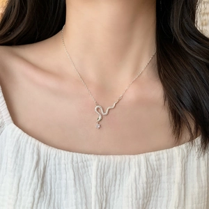 Elegant silver snake necklace with sparkling zircon pendant shown on model neck