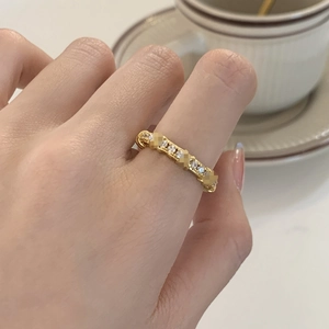 Elegant gold woven band ring with sparkling cubic zirconia shown on model's hand